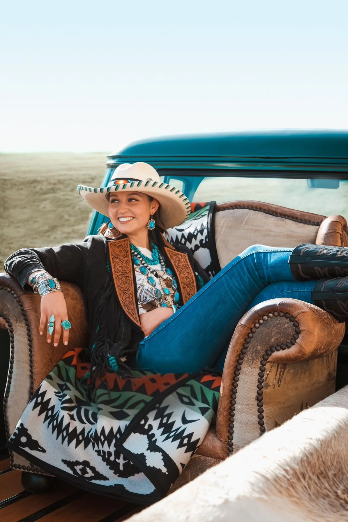 Photo shows woman in the back of a truck wearing styles by Persimmon Hill from the National Cowboy Museum