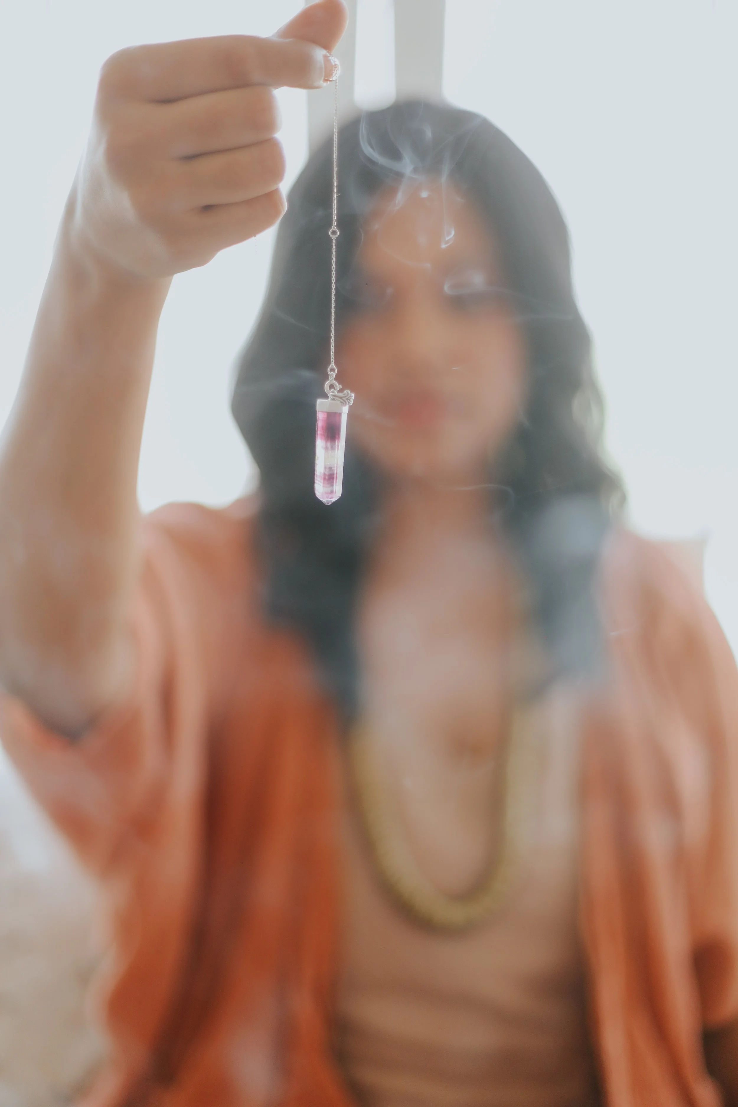 Esther Milanzi holding a pendulum in a hypnotherapy session