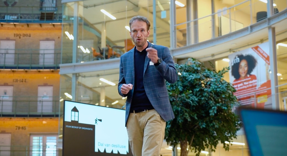 Maarten Brand tijdens een lezing voor de zaal
