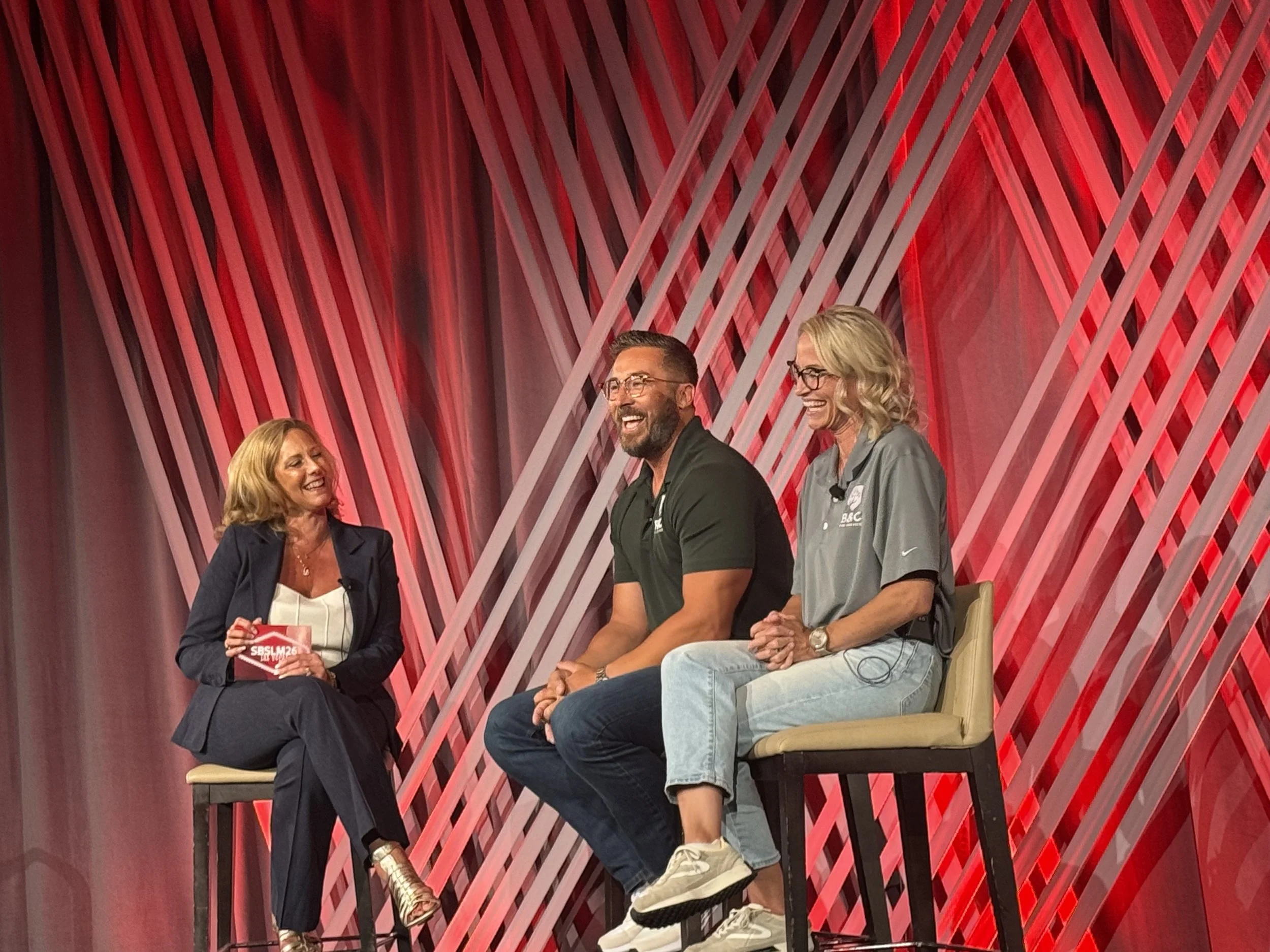 B&C Tree Service owners Alex and Jess Carey speaking on stage at the 2026 ADP Grit and Wisdom Awards