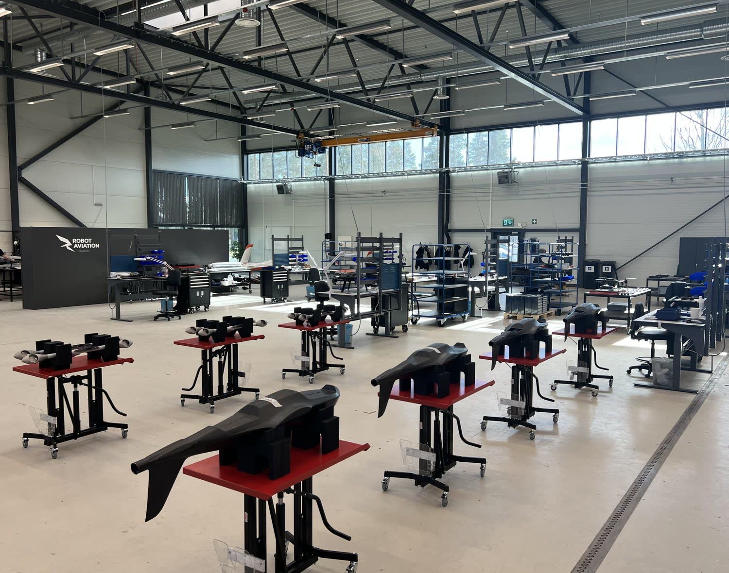 Robot Aviation's engineering workshop with rows of workbenches and equipment.