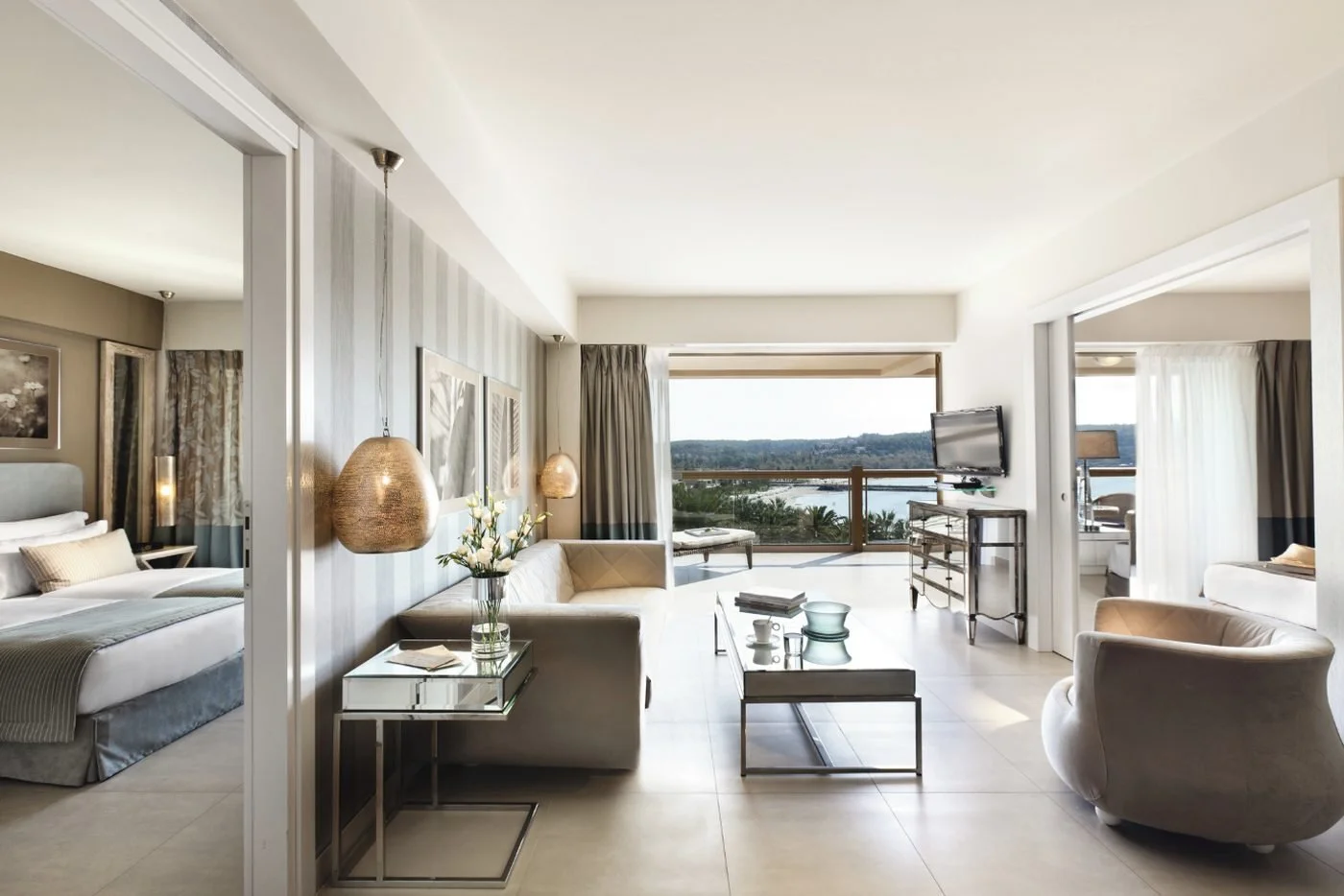 A Two Bedroom Family Suite living room with a bedroom on each side and a balcony looking over the bay