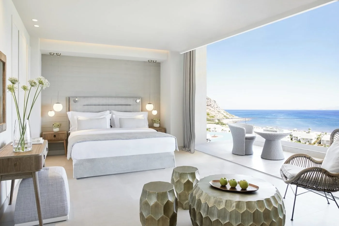 A Panorama Junior Suite at Ikos Aria with a balcony overlooking the resort, the beach and the sea
