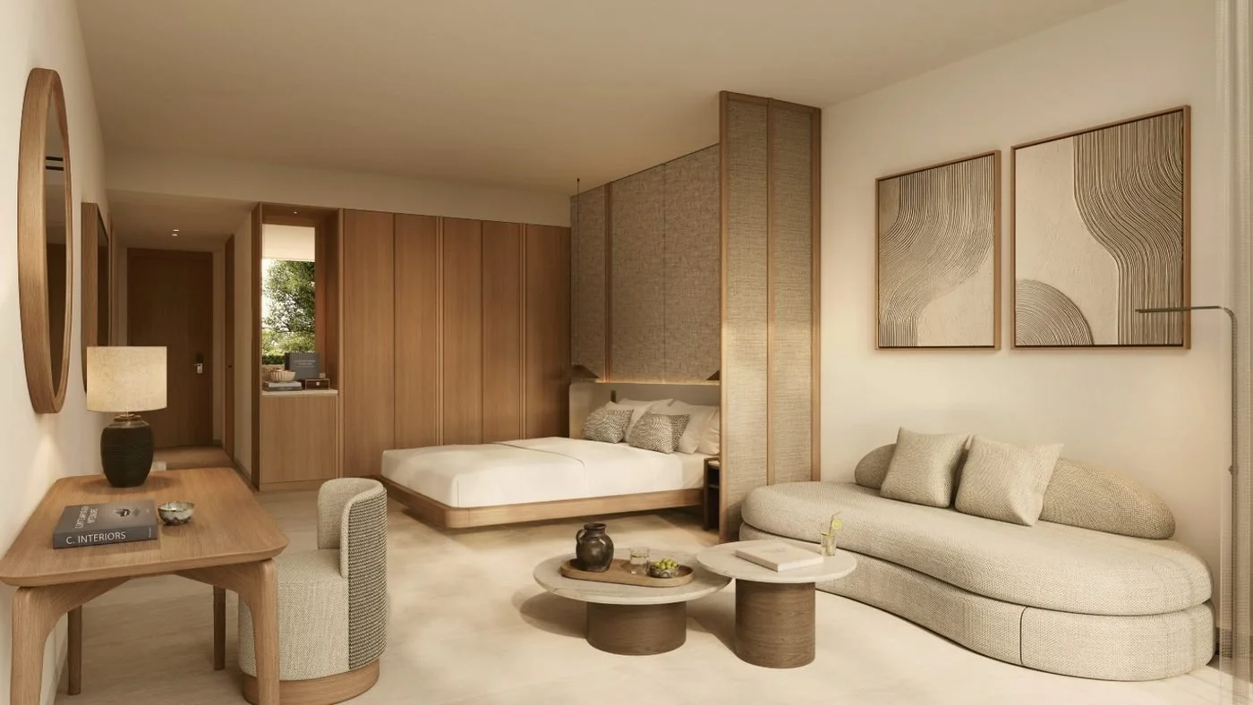 Artist's impression of one of Porto Sani's new suites, with a bed, a curved sofa and two round coffee tables