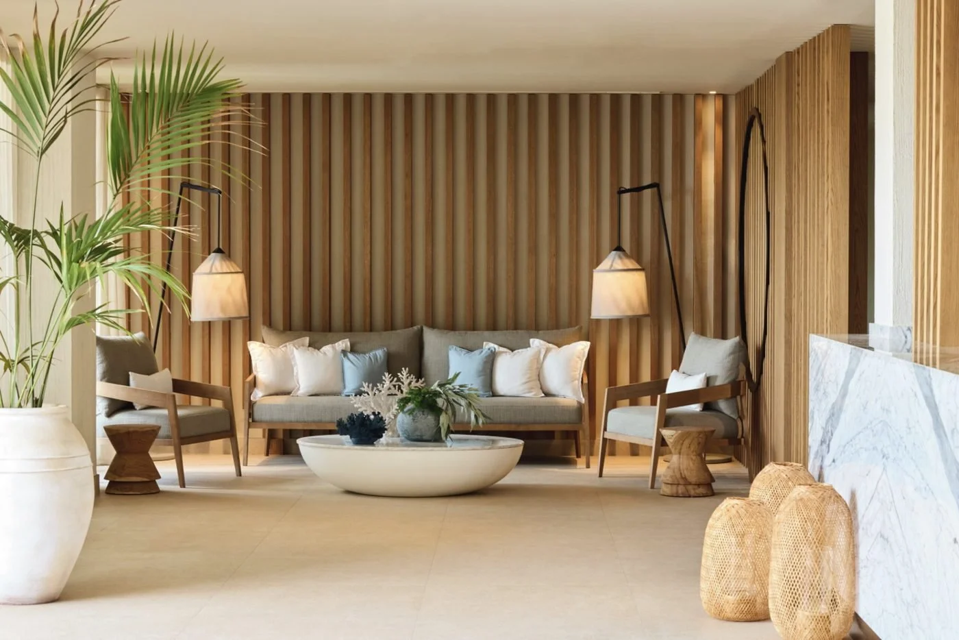 The calm spa reception at Ikos Andalusia, with a sofa, soft lamps and wooden slatted walls