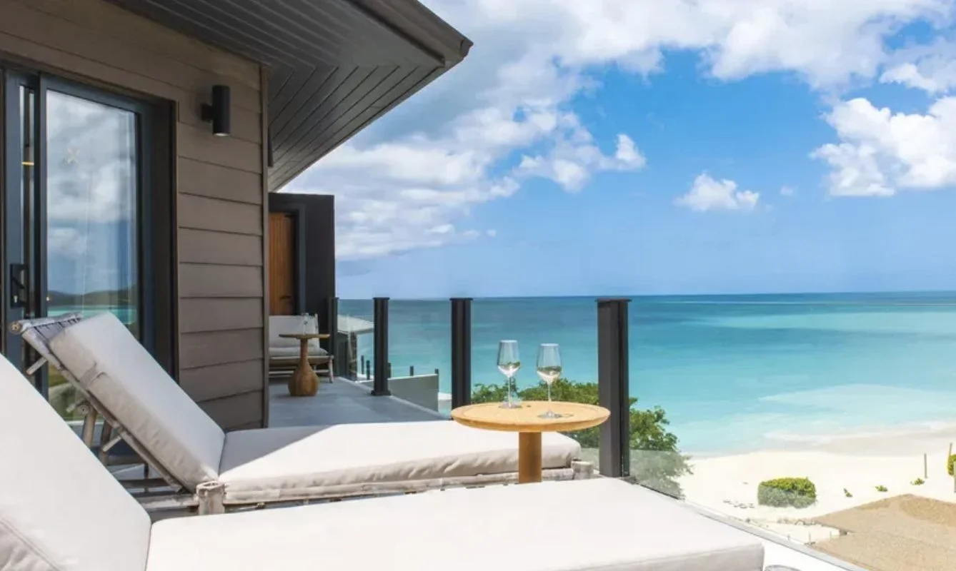 A terrace looking down to a white sand beach