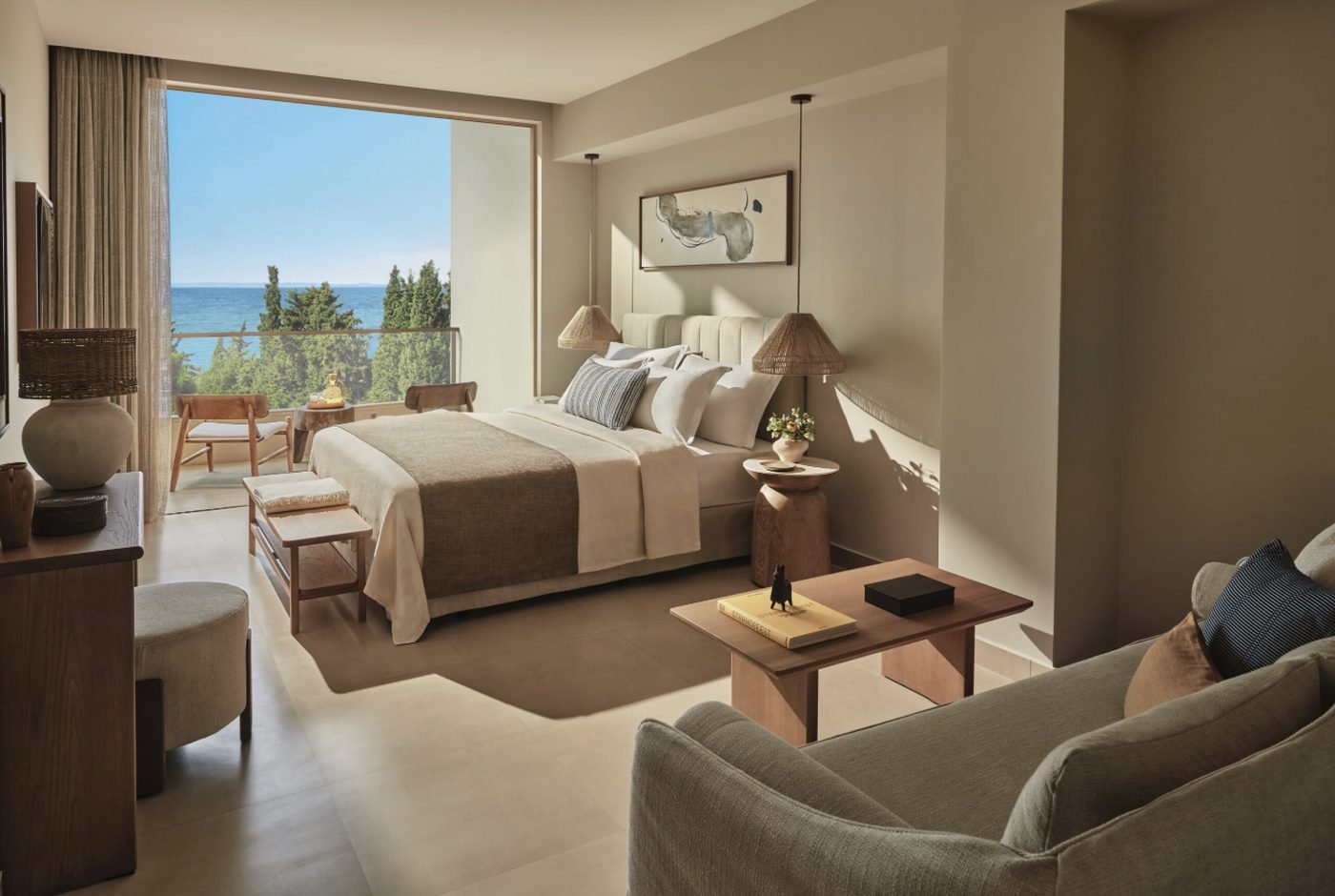 A Superior Double Room at Ikos Olivia with a balcony looking over pine trees to the sea