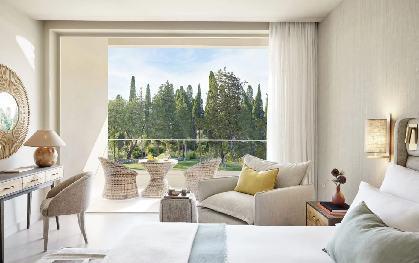 A Superior Double Room Garden View, with a balcony table and chairs looking out to cypress trees