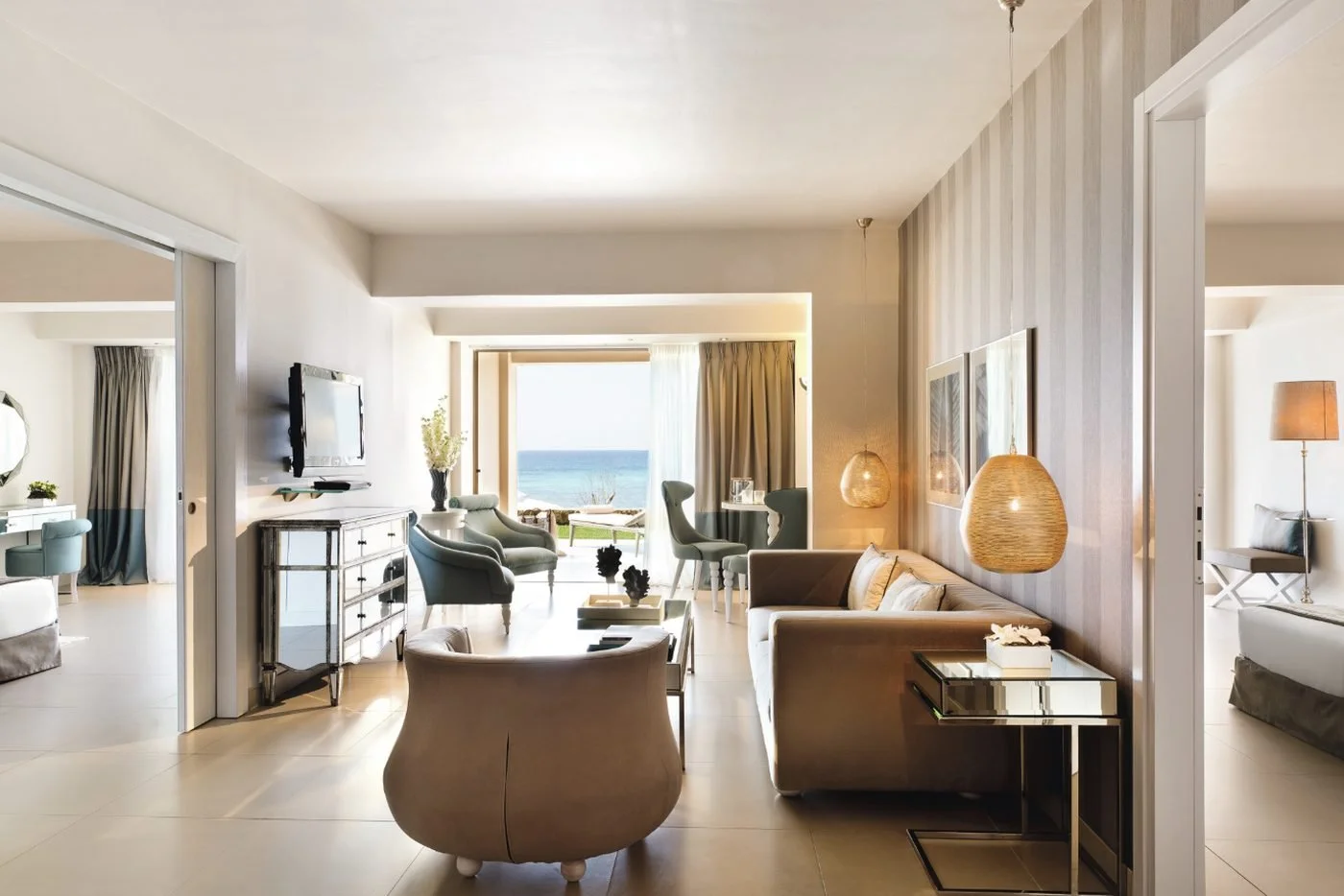 The living room of a Two Bedroom Family Suite Beach Front opening onto its garden and the sea