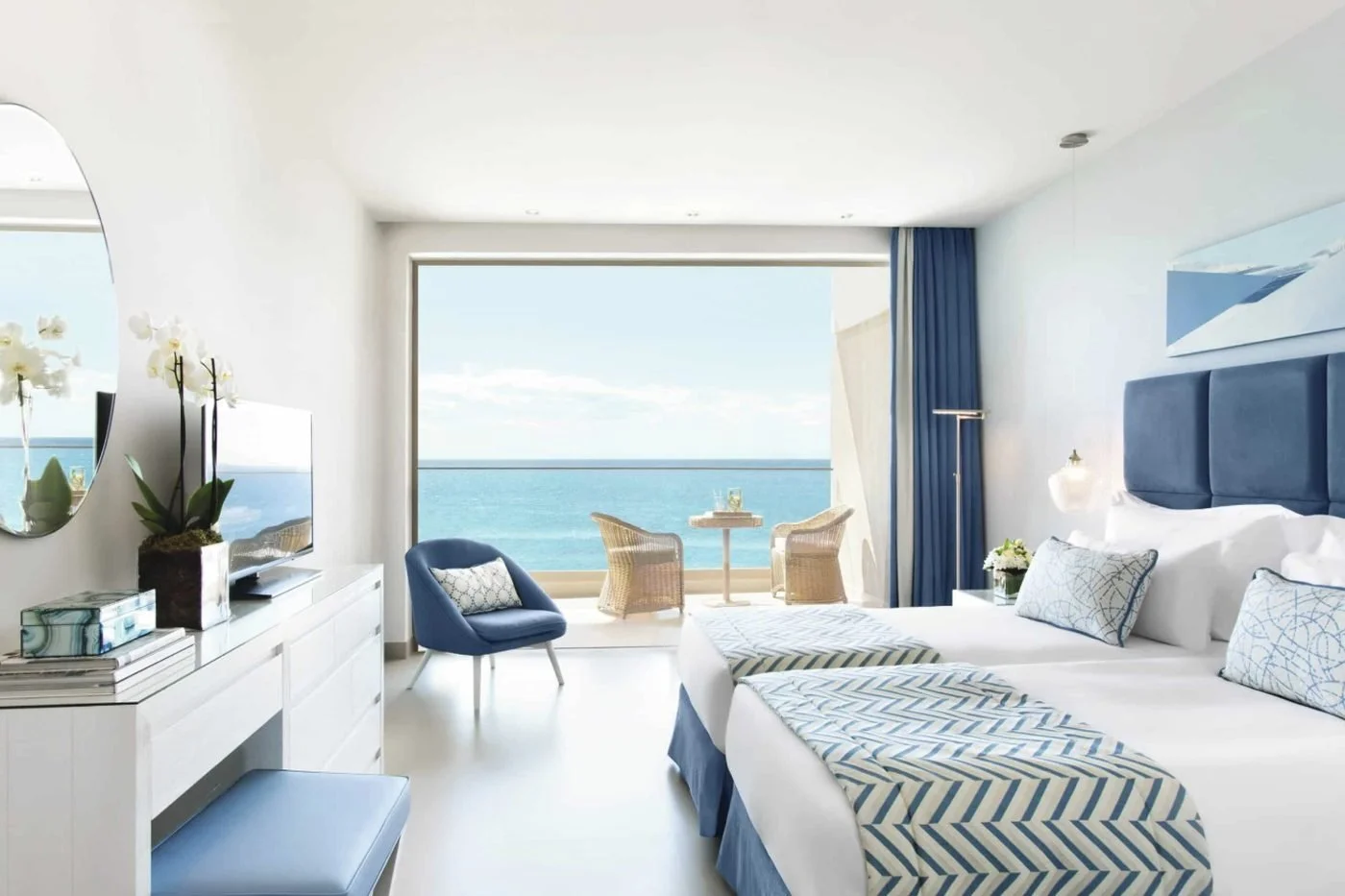 A Family Room Sea View at Ikos Oceania with two beds and a balcony facing the sea