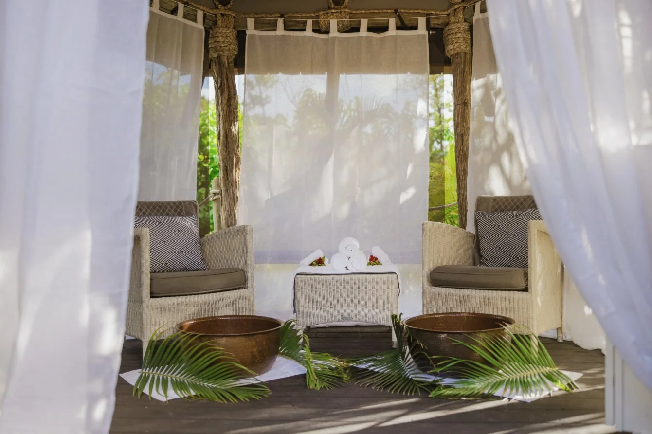 An open-air spa pavilion with white drapes