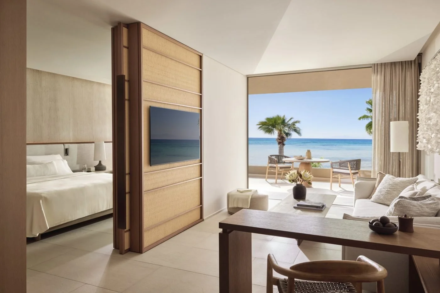 A one-bedroom residence at Sani Asterias, with the bedroom beside a sitting room and a balcony over the sea