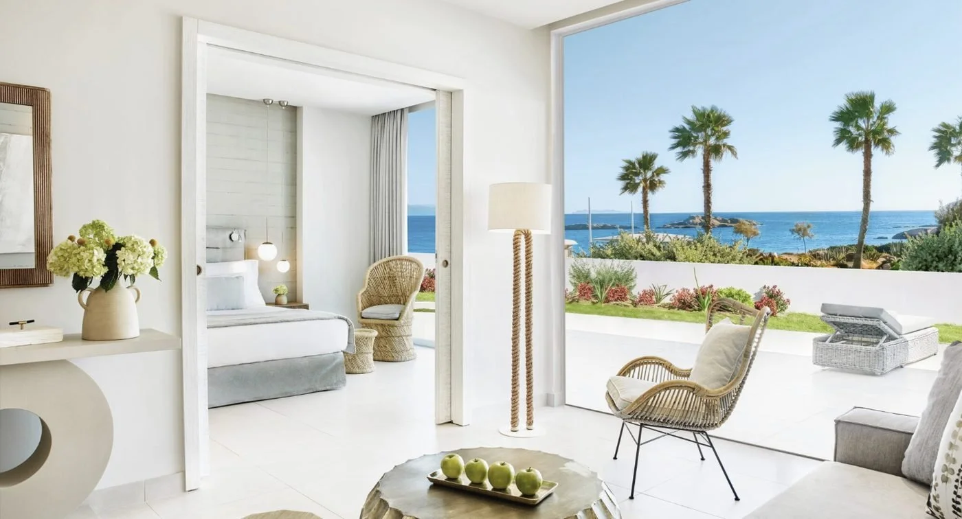 A One Bedroom Suite at Ikos Aria with a living area opening onto a private garden and the sea