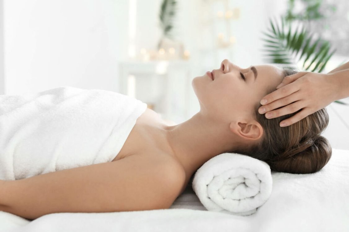 A guest relaxing during a head massage at the spa