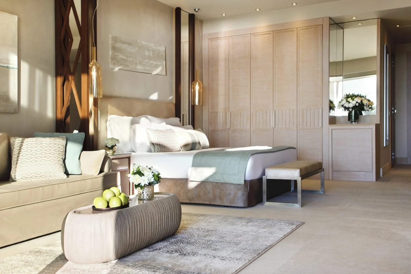 A Deluxe Junior Suite at Sani Dunes, with its bed and sitting area beside a wall of wardrobes