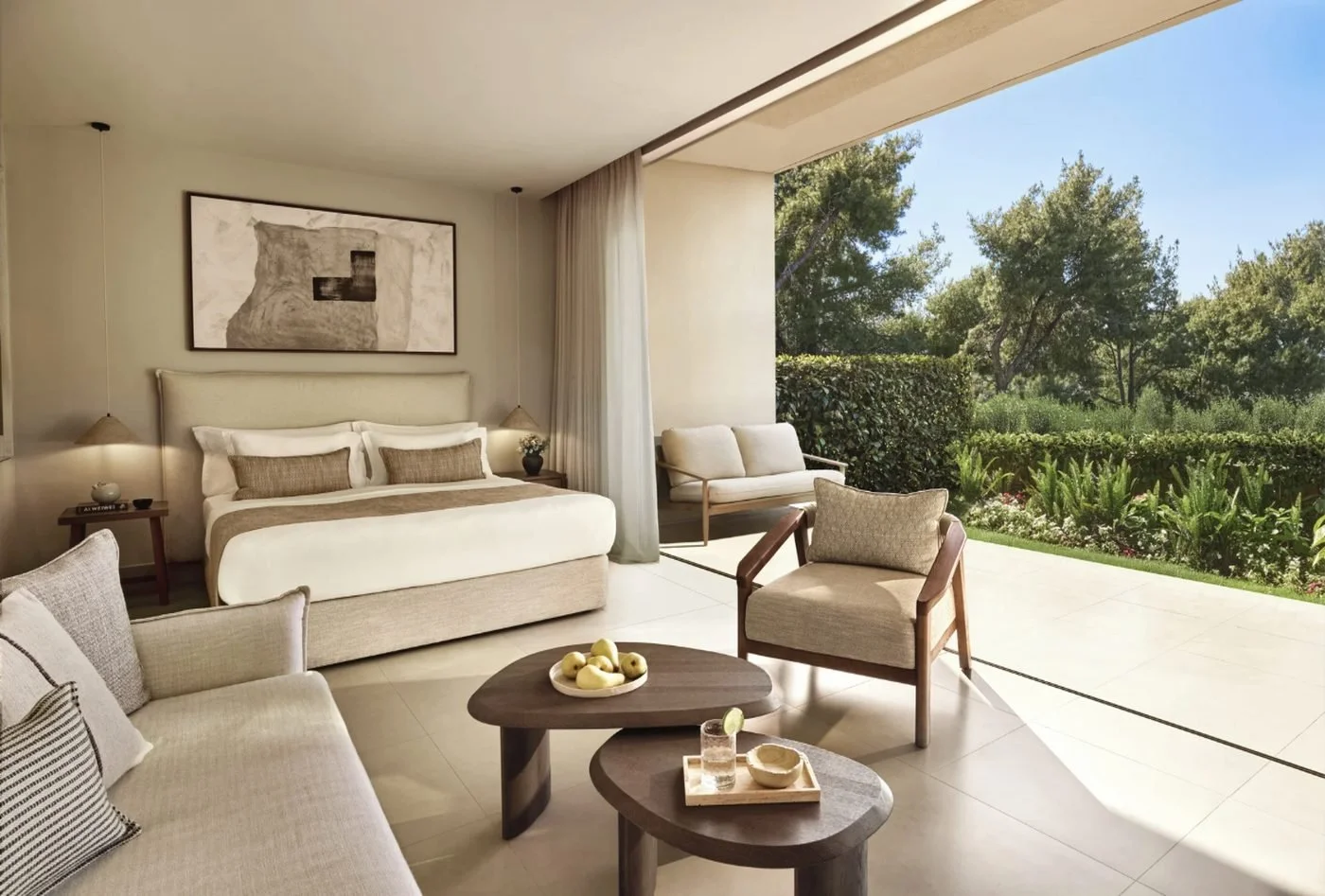 A Double Room at Sani Club with a sofa and armchair, opening onto a terrace and the garden