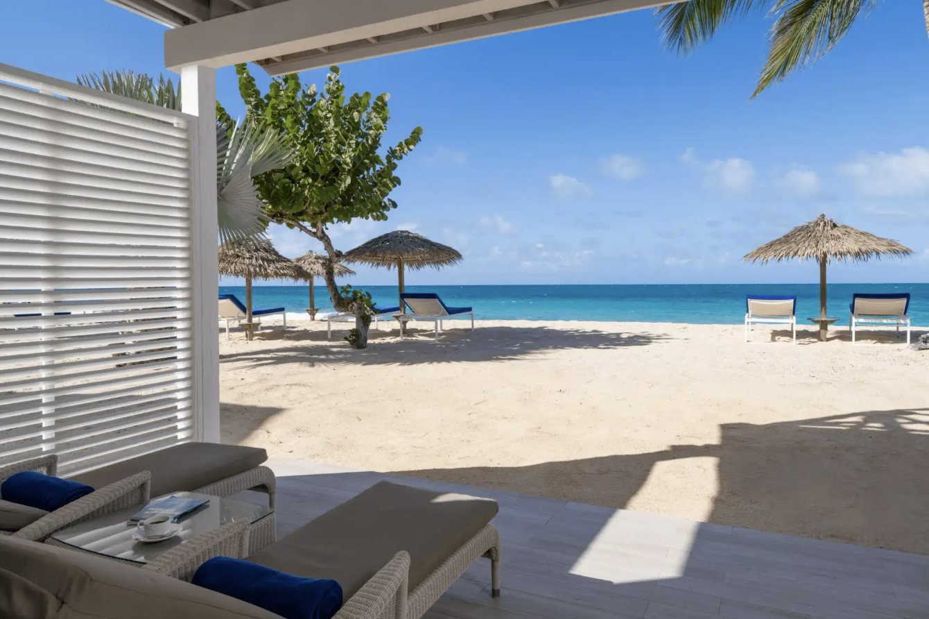 A beachfront patio opening onto white sand