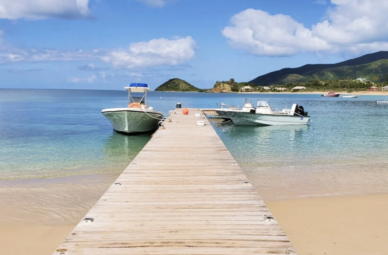 The wooden jetty and boats over clear water