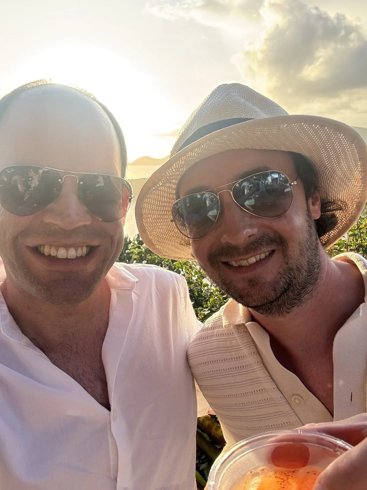 Ben and Hugh raising a rum punch at sunset in Antigua