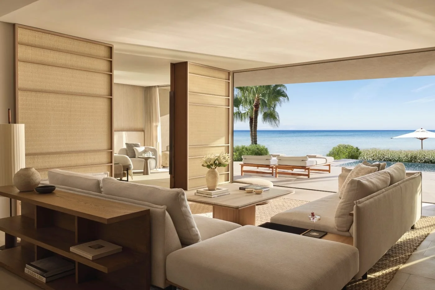 Living room of a grand residence at Sani Asterias opening onto loungers, a pool and the sea
