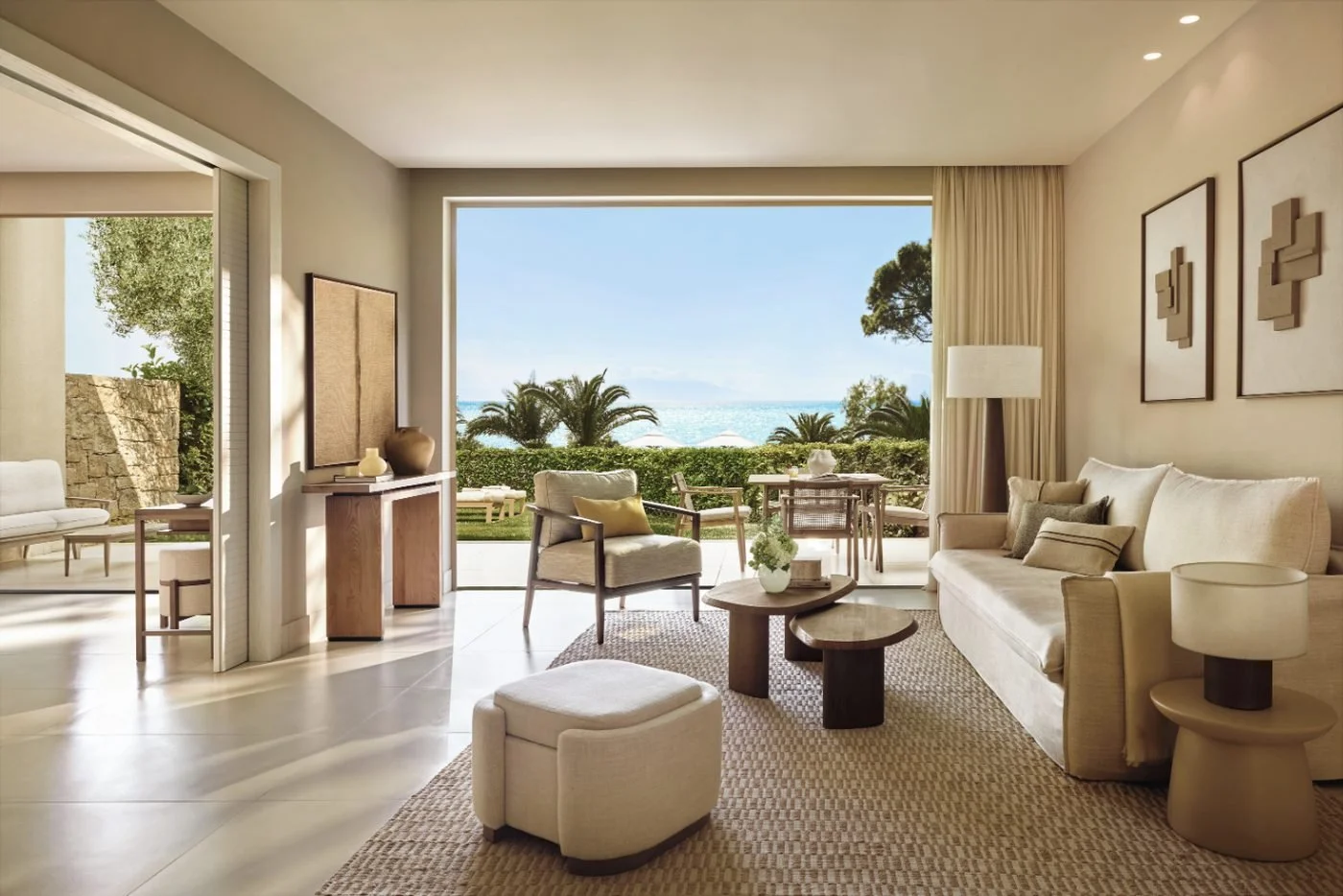 Living room of a two-bedroom bungalow suite at Sani Club, with a garden terrace and the sea beyond