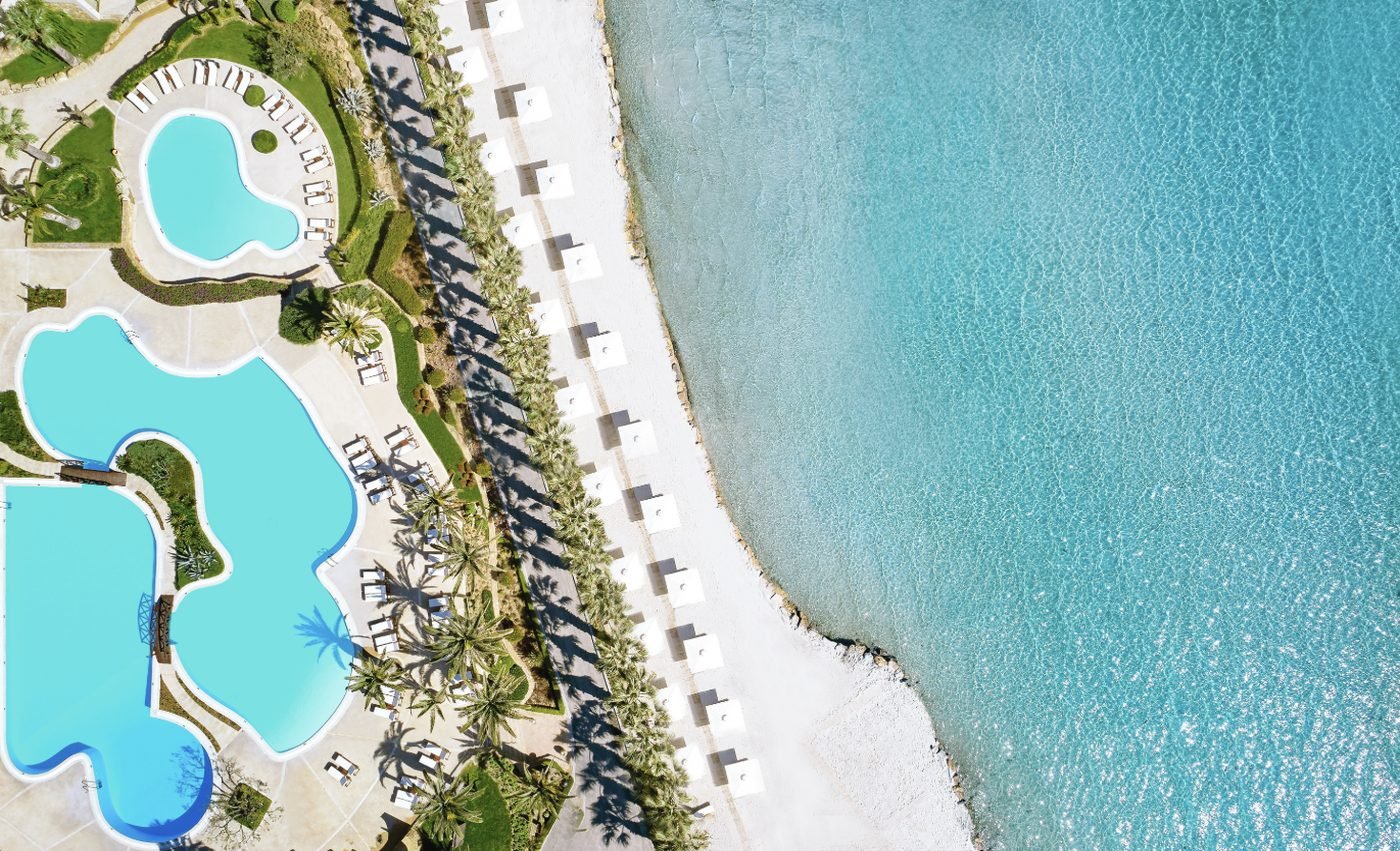 The pools, palms and beach at Sani Beach from the air