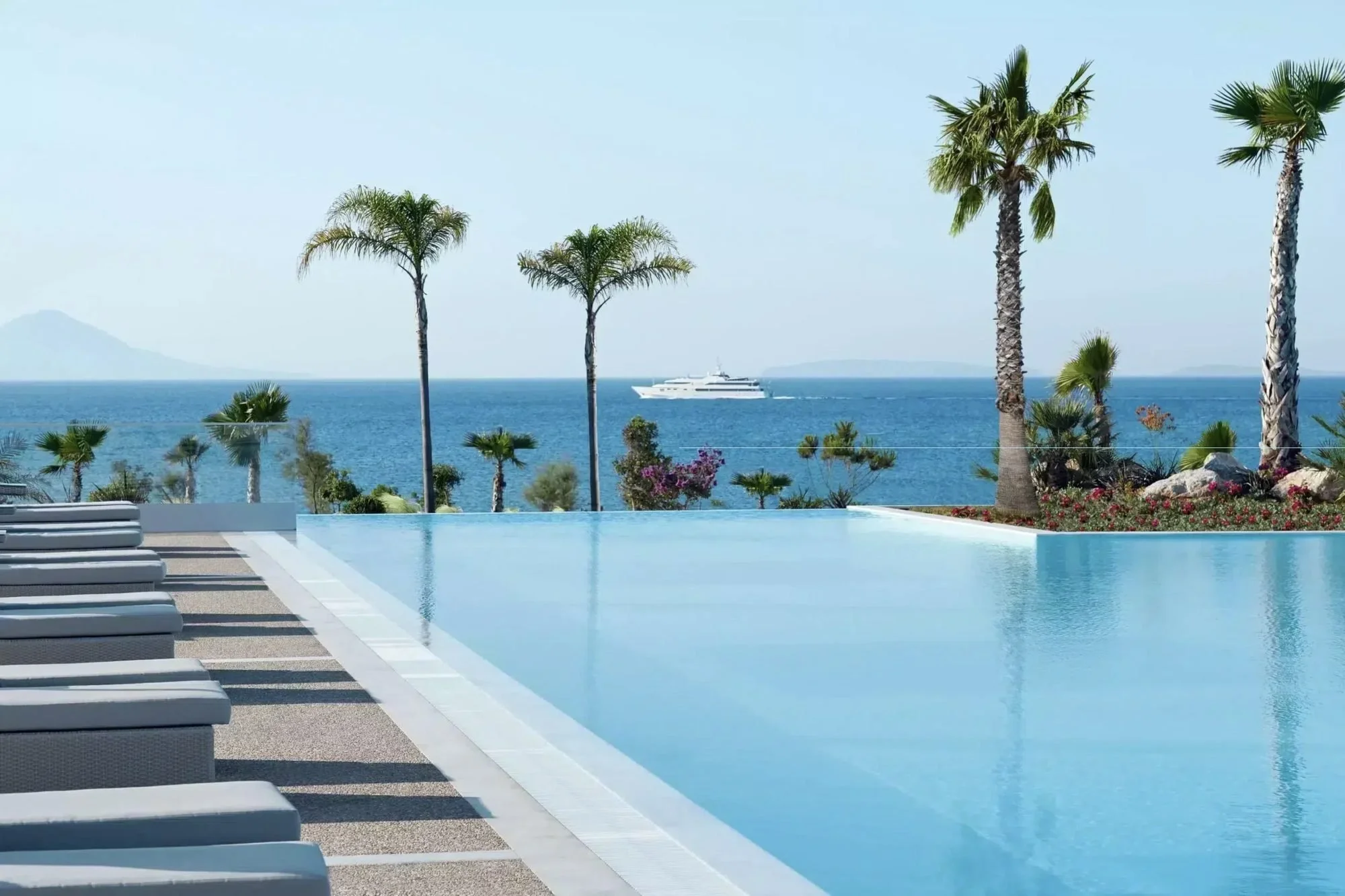 An infinity pool edged with palms looking out to sea at Ikos Aria on Kos