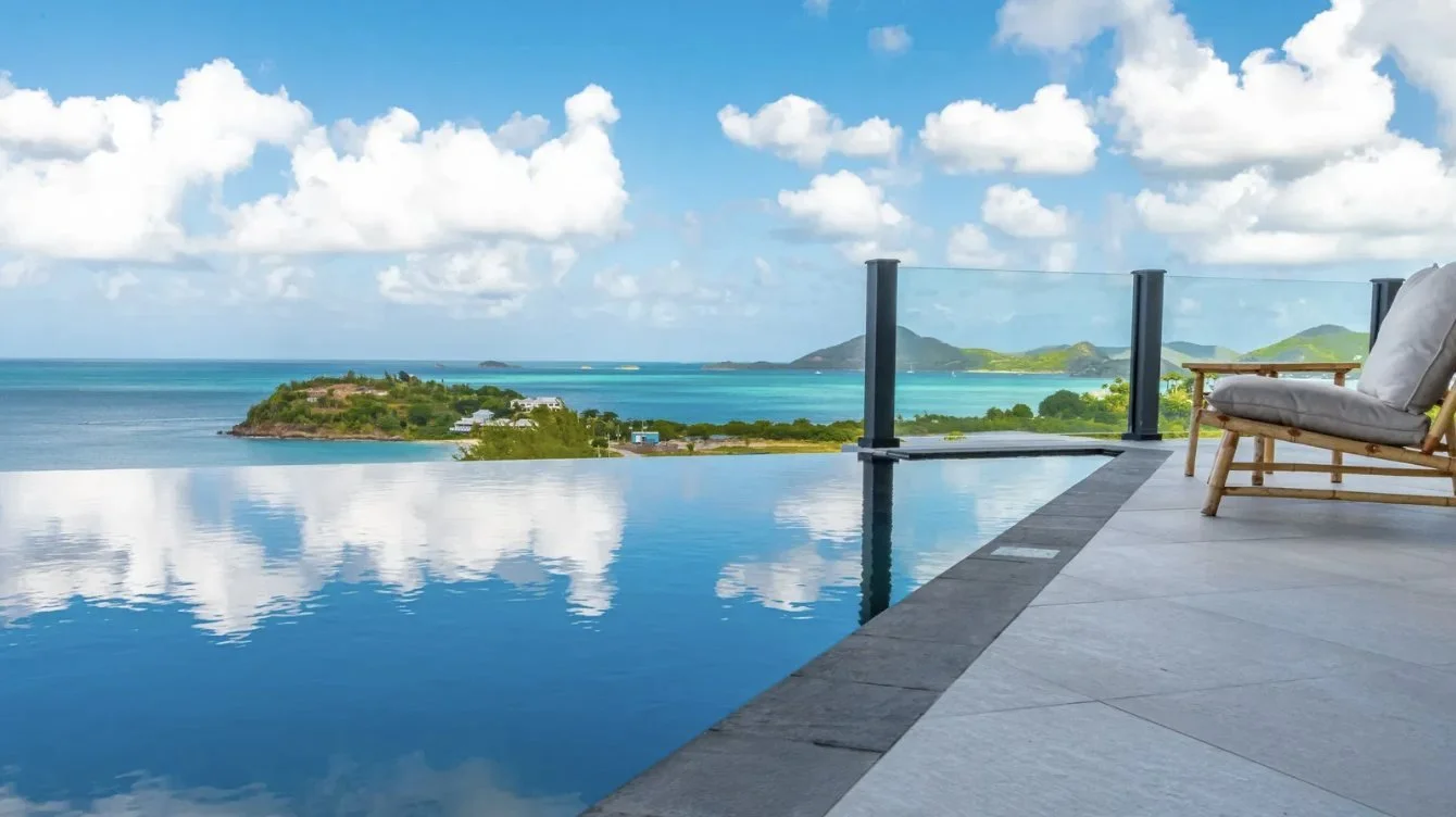 A suite's infinity pool reflecting the sky above the sea