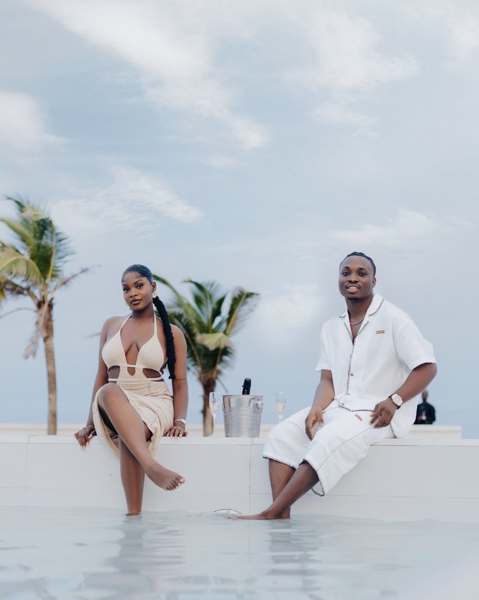 A couple relaxing by an infinity pool with champagne