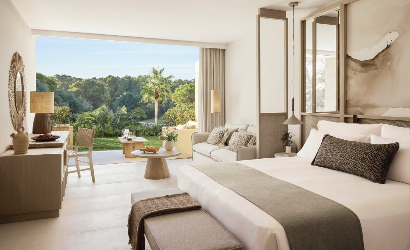 A Junior Suite Private Garden opening onto a lawn with palms and pines