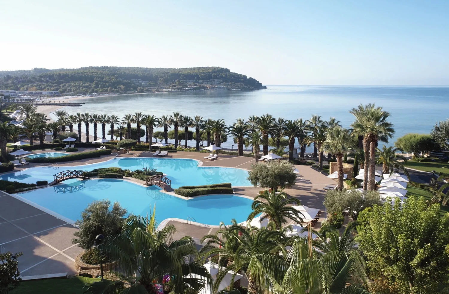 Sani Beach's pools and palm promenade above the bay