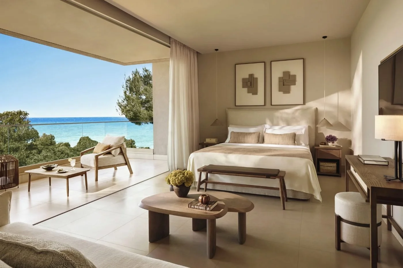 A Junior Suite at Sani Club with its glass-fronted balcony open to pine trees and the sea