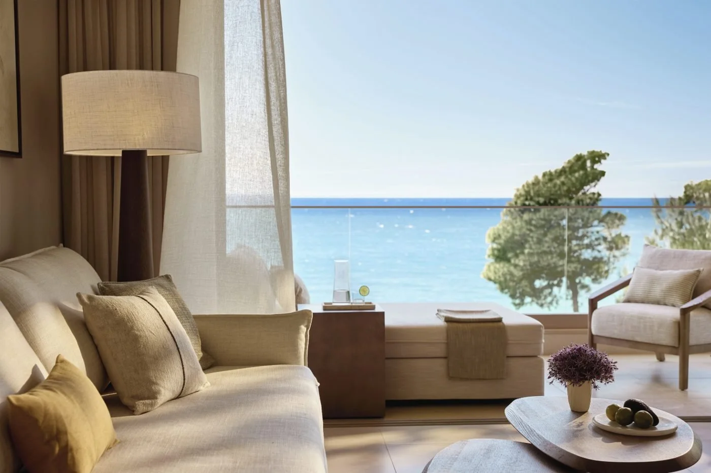 The sitting area of a Family Suite Grand Balcony at Sani Club, looking over the balcony to the sea