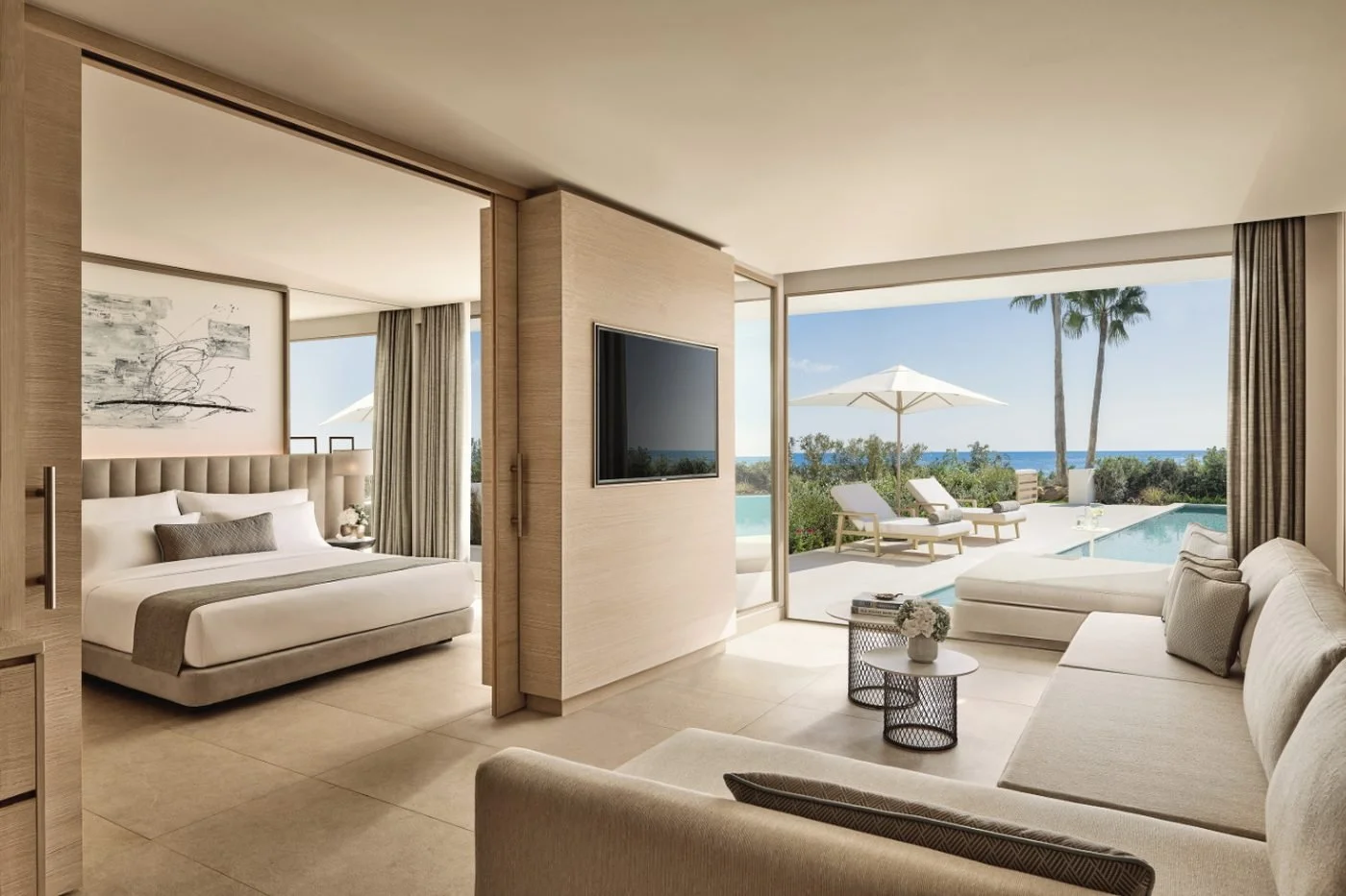 A Deluxe One Bedroom Suite Private Pool with a living room opening onto loungers, a parasol and a private pool