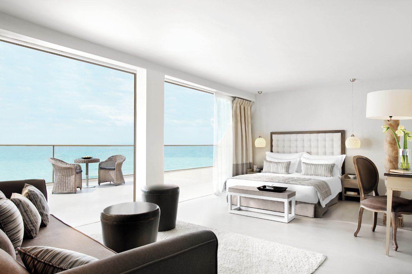 A Junior Suite Panorama with a sofa, floor-to-ceiling windows and a balcony over the Aegean