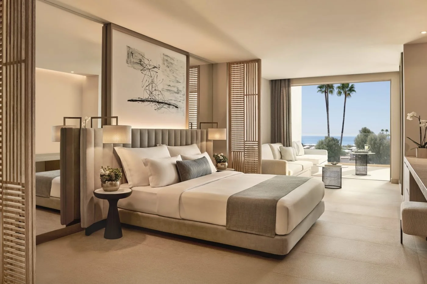 A Junior Suite at Ikos Andalusia with slatted wooden screens, a double bed and a balcony with palm trees and the sea