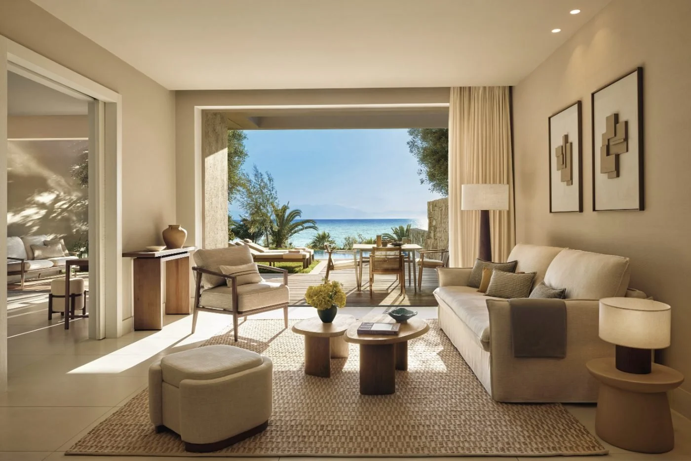 Living room of a One Bedroom Bungalow Suite at Sani Club opening onto a terrace with sea views