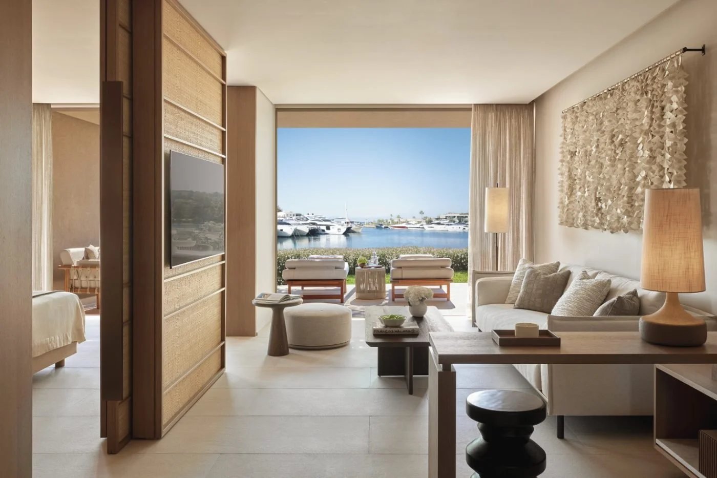 Living room of a one-bedroom residence at Sani Asterias opening onto a garden terrace and the yachts of Sani Marina