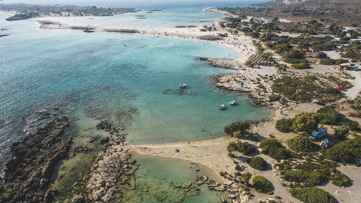 Aerial view of turquoise shallows, rocky points and sandy coves on the west coast of Crete