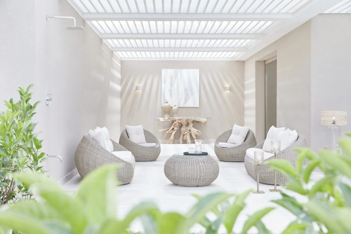 The shaded terrace of a Deluxe Junior Suite Bungalow, with wicker armchairs among garden greenery