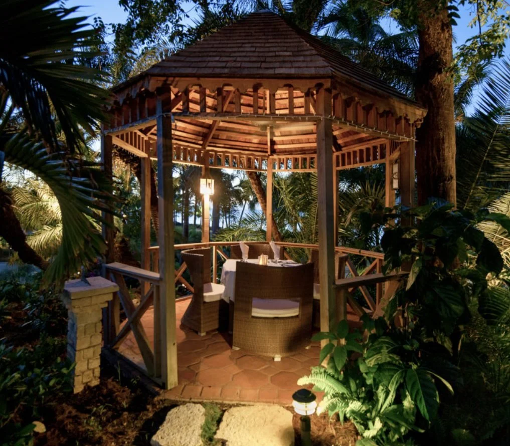 A lantern-lit gazebo set for dinner in the gardens