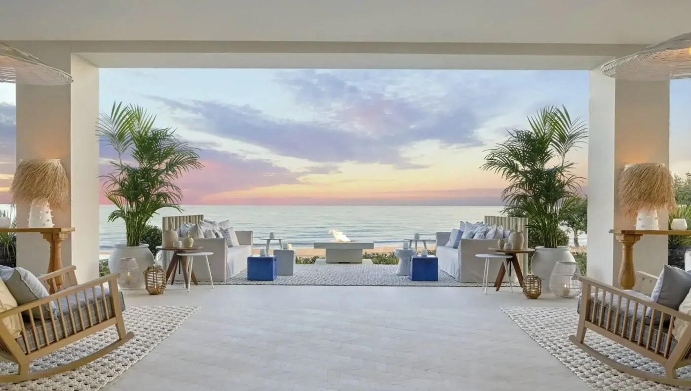 Sofas around a fire pit on the Main Bar terrace, looking out to the sea at sunset