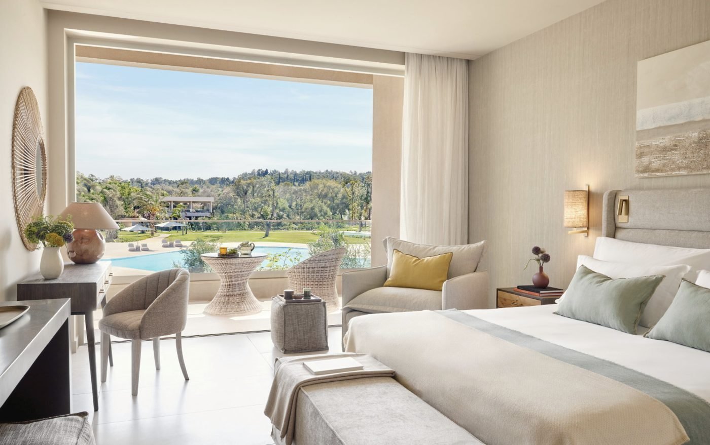 A Superior Double Room Pool View, its balcony overlooking a pool and green lawns
