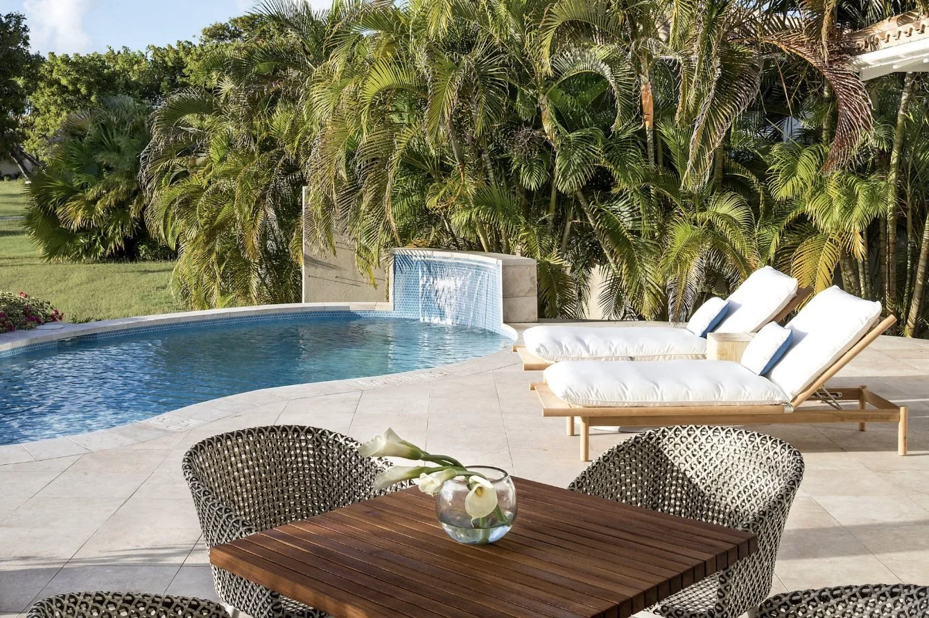 A private pool and loungers in a tropical garden