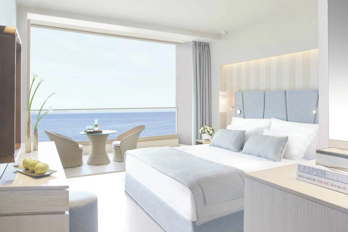 A Superior Double Room with a wall of glass opening onto a balcony above the sea
