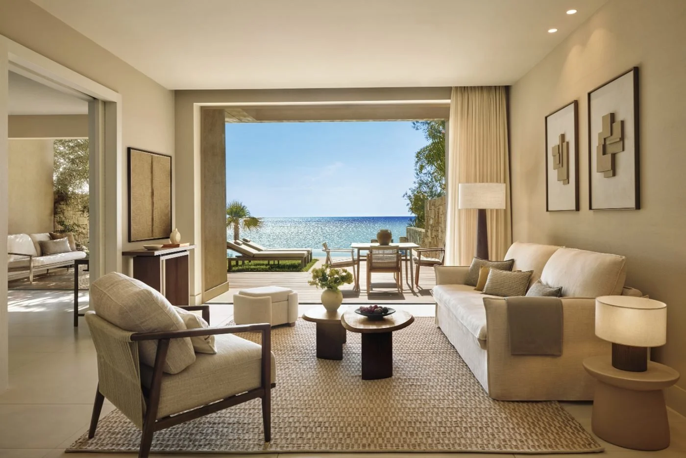 Living room of a two-bedroom bungalow suite at Sani Club opening onto a terrace and the sea