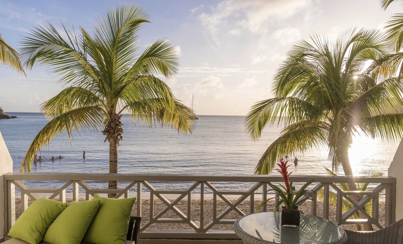Balcony view through palms to the beach at Carlisle Bay