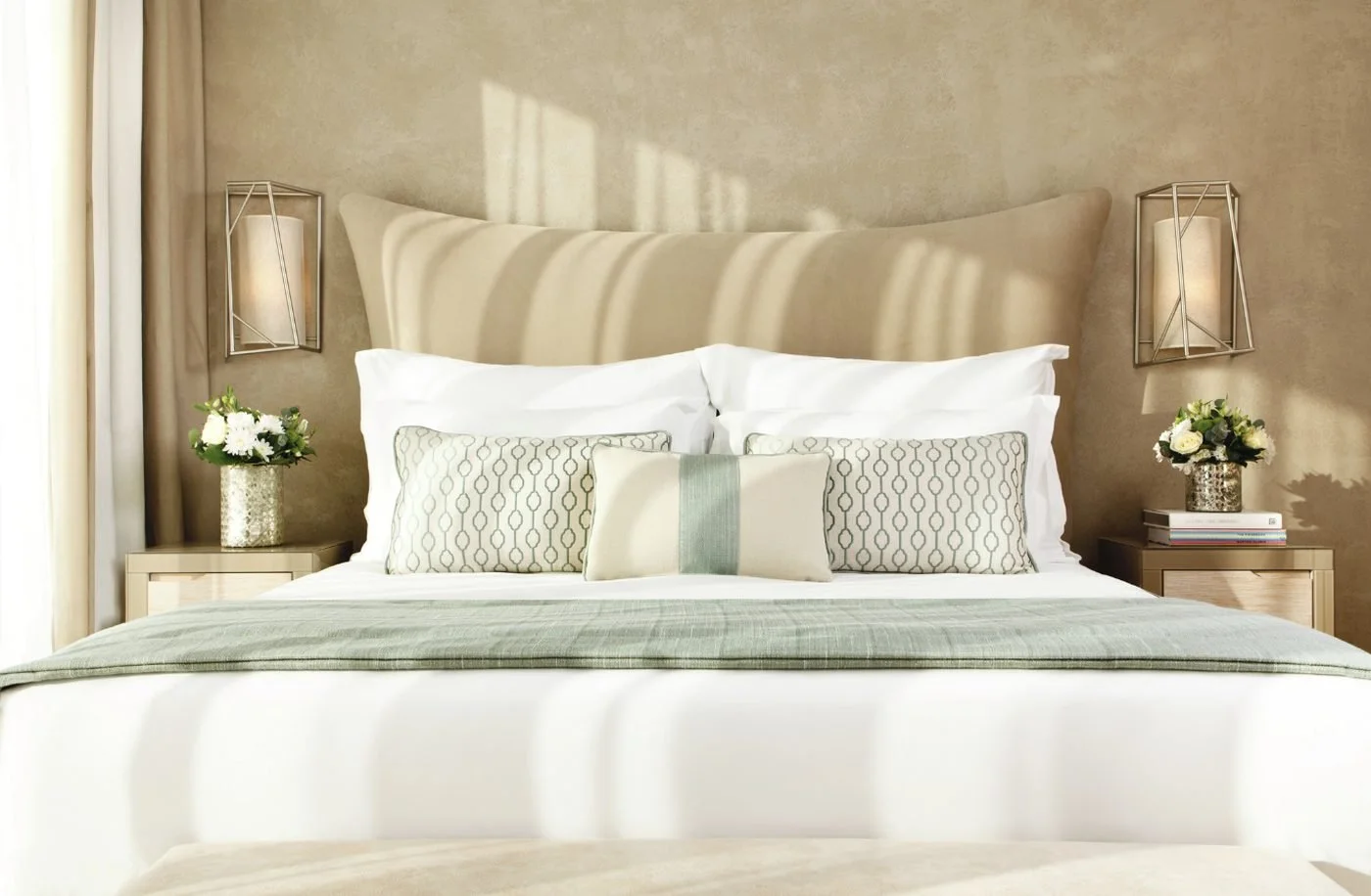 A double bed with soft green and cream cushions in a Family Room at Sani Dunes