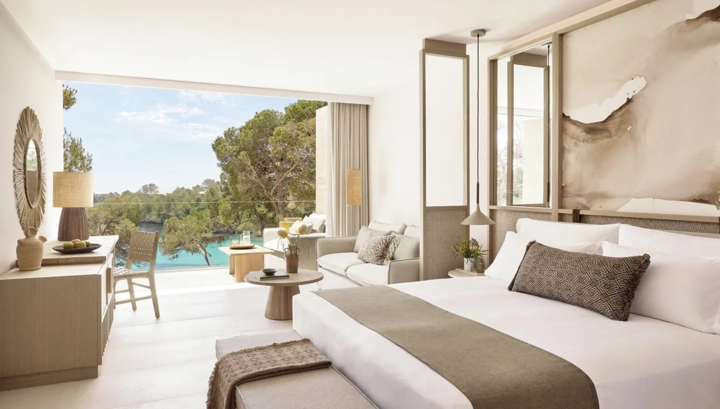 A Deluxe Junior Suite looking out through the pines to a turquoise cove