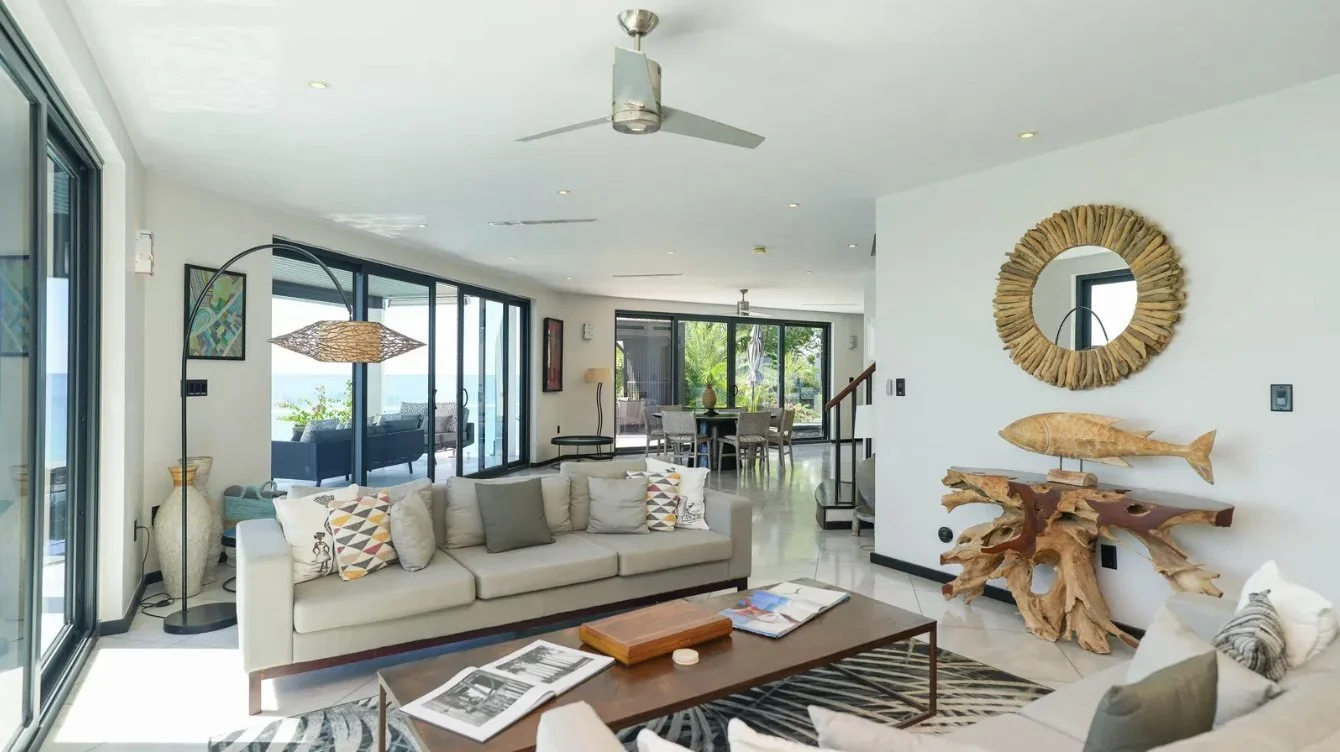 A glass-walled villa living room looking out to sea